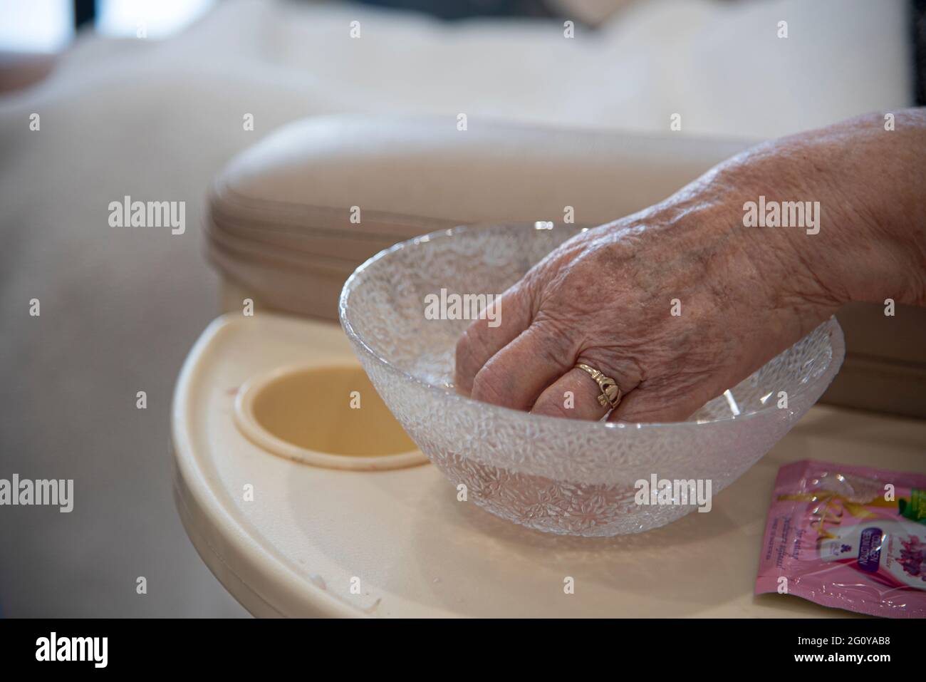 Une femme hispanique de 84 ans se fait offrir un ensemble pédicure/manucure dans son salon de beauté local. Banque D'Images