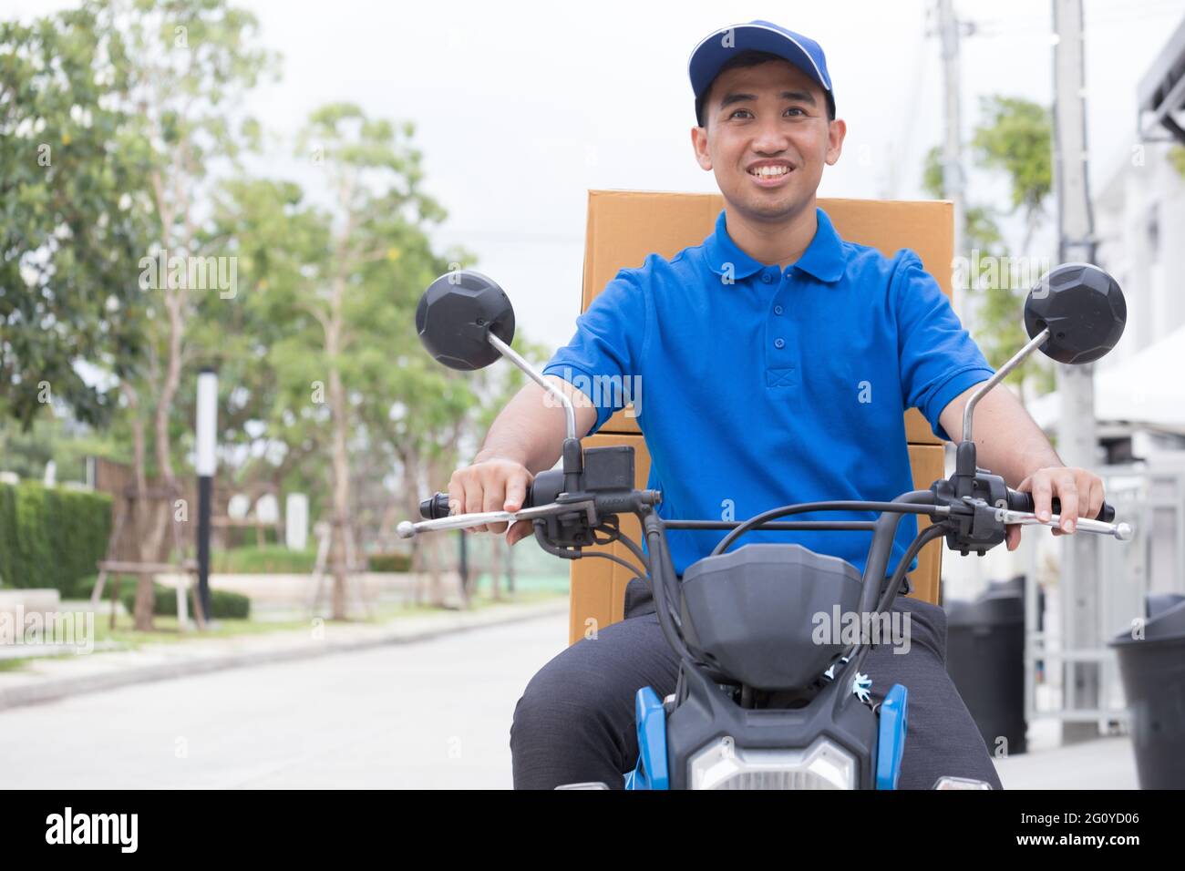 Livreur sur la moto à coffre boîte à colis de conduite rapide en rush. La prestation de service de messagerie en ligne de commande. Livraison express dans des délais spécifiés par l'al. Banque D'Images