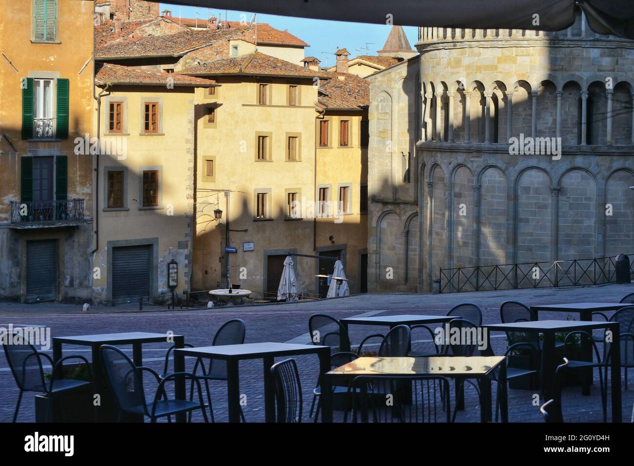 bâtiments anciens dans l'ancienne place principale d'arezzo avec des tables de restaurant vides à l'aube Banque D'Images