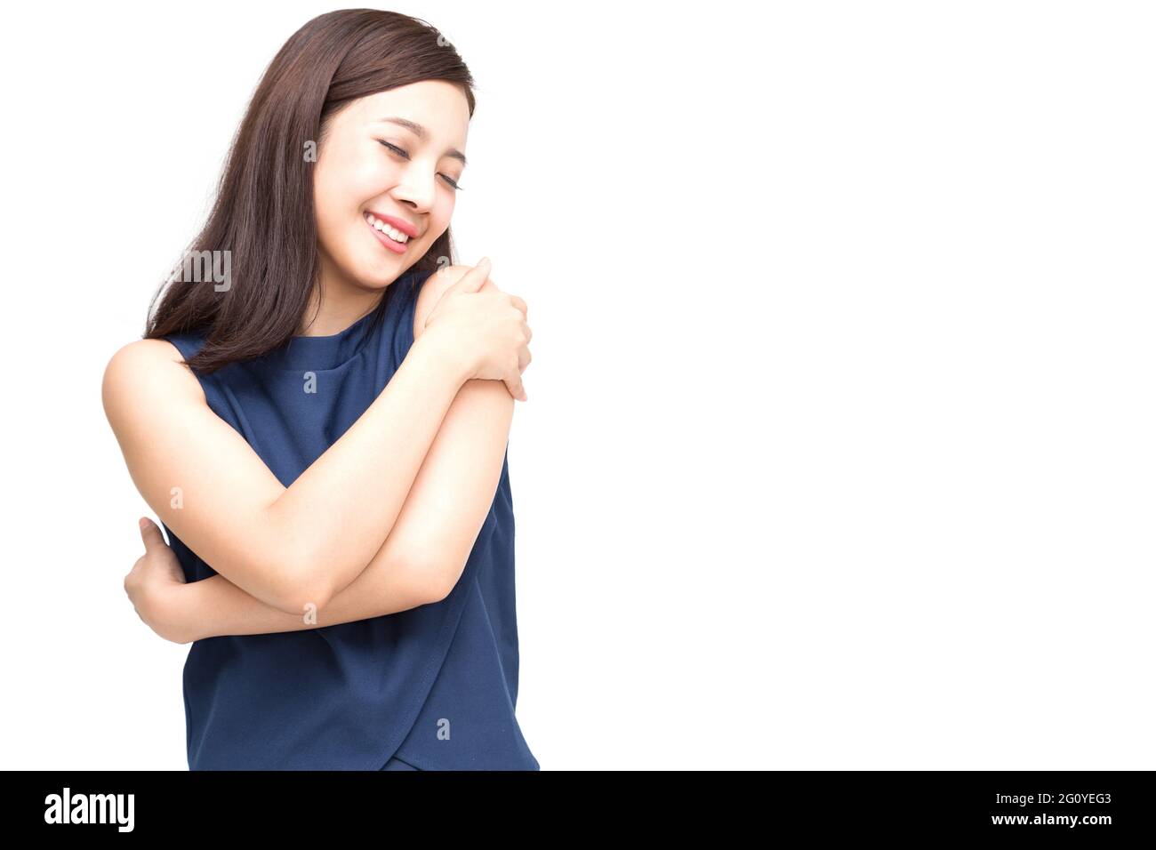 Happy young casual asian woman hugging elle-même isolé sur fond blanc. Aimer vous-même concept Banque D'Images