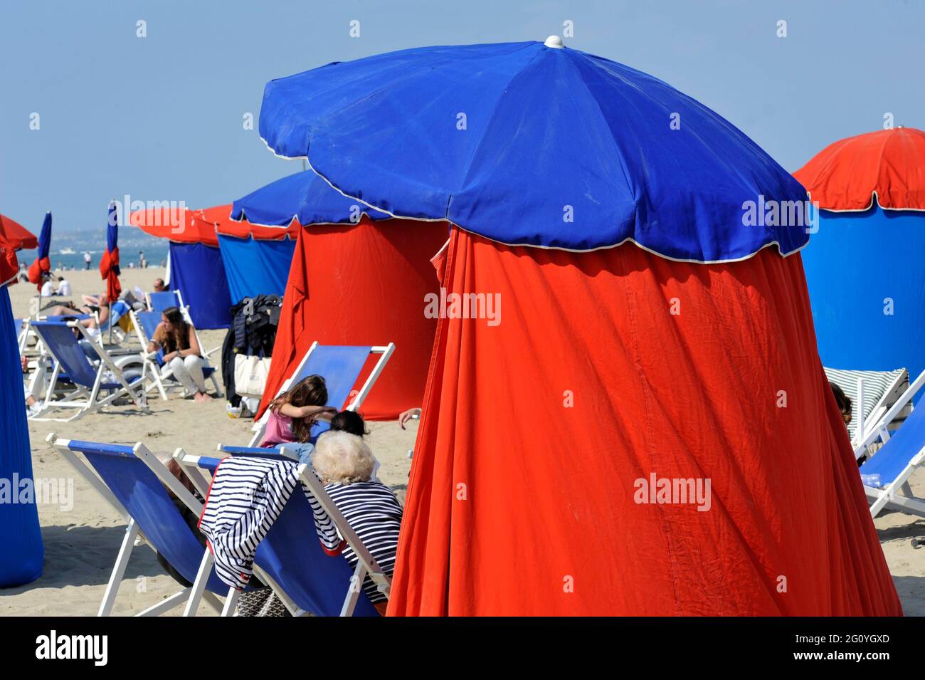 FRANCE. DEAUVILLE (14) FEMME SENIOR UNTER A PARASOL ON THE BEACH Banque D'Images