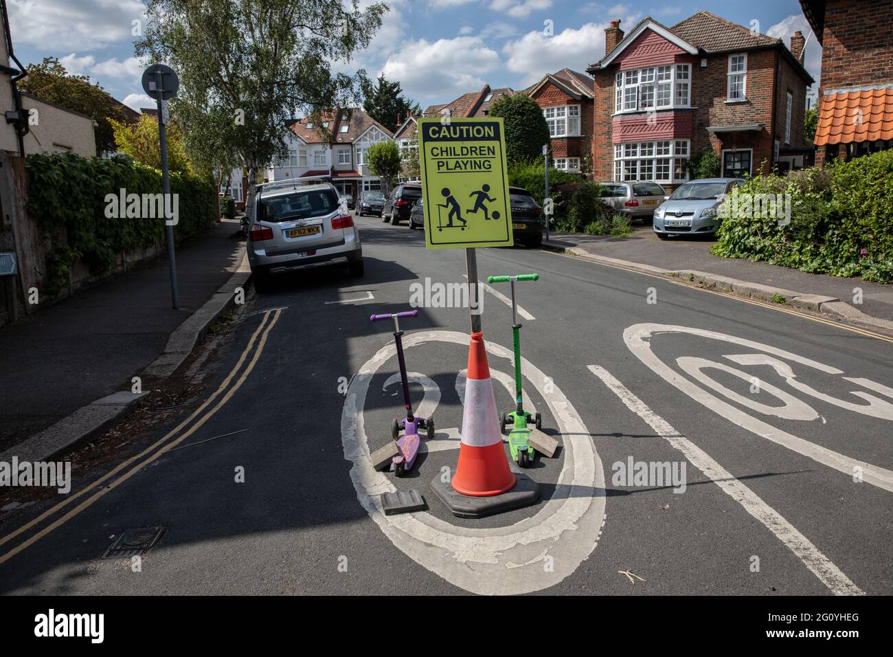 ATTENTION enfants jouant signe positionné pour ralentir la circulation à l'entrée de cul-de-sac résidentiel, Angleterre, Royaume-Uni Banque D'Images