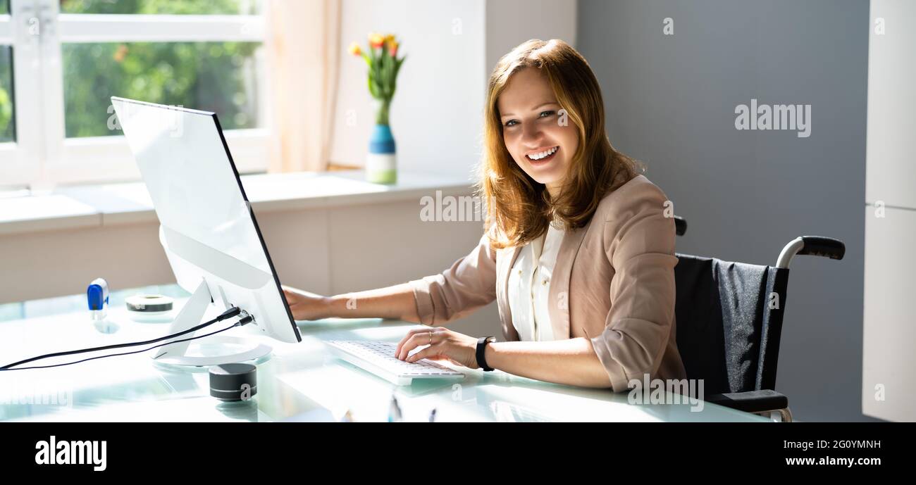 Femme d'affaires handicapée utilisant un ordinateur de bureau au bureau Banque D'Images