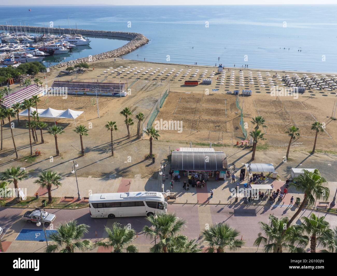 Vue aérienne supérieure donnant sur l'arrêt de bus central avec les personnes qui attendent à la promenade des palmiers de Finikoudes, la mer méditerranée, les yachts dans le port et la plage. Banque D'Images