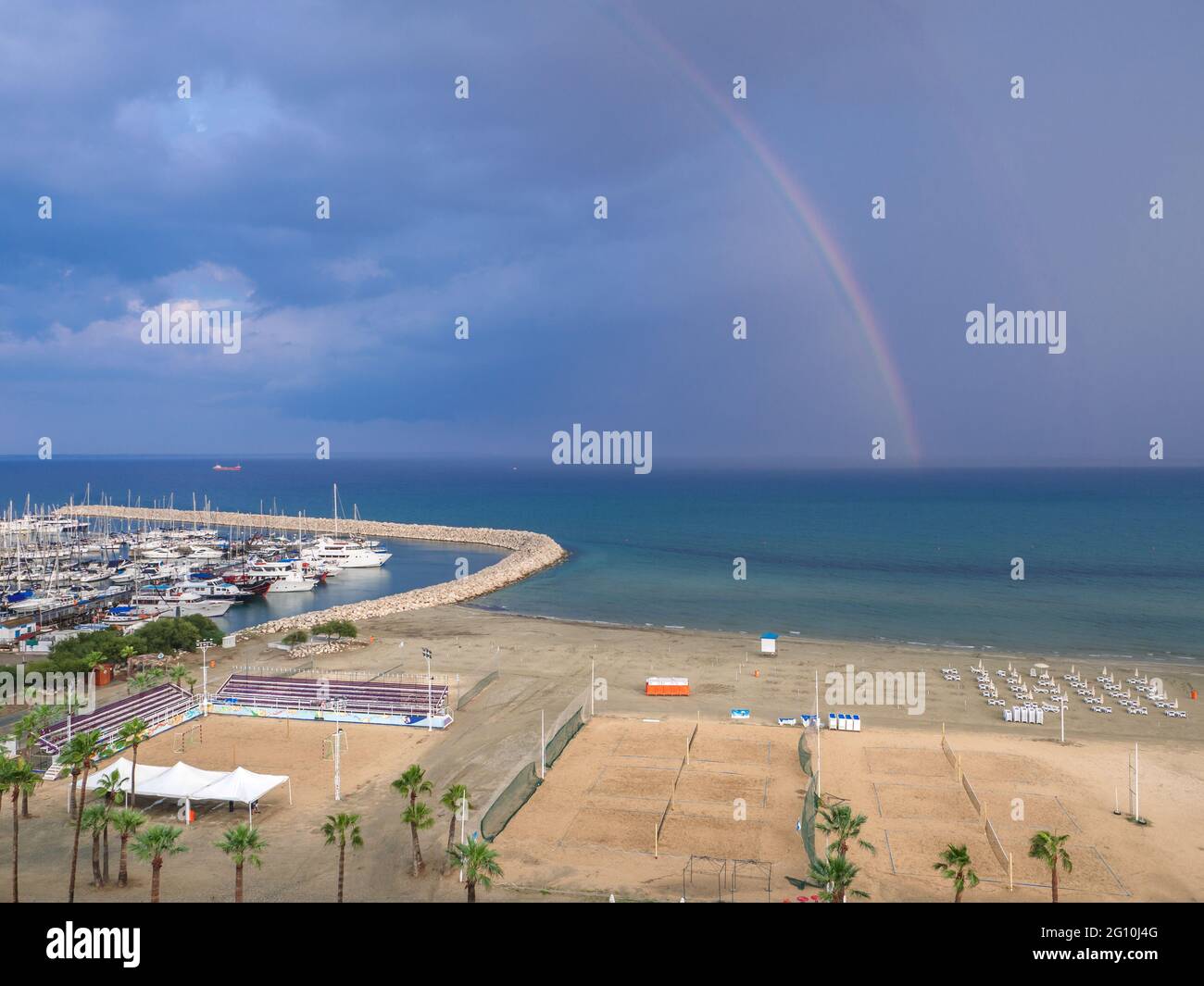 Vue aérienne sur le terrain de volley et la jetée avec yachts sur la mer Méditerranée près de la promenade des palmiers de Finikoudes dans la ville de Larnaca. Banque D'Images