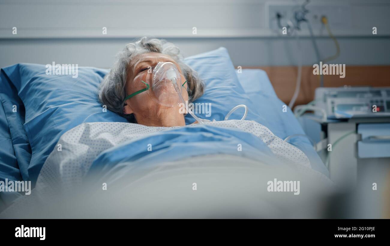 Hôpital: Portrait d'une belle femme âgée portant un masque d'oxygène dormant dans le lit, se rétablissant complètement après la maladie. La vieille dame rêve d'elle Banque D'Images