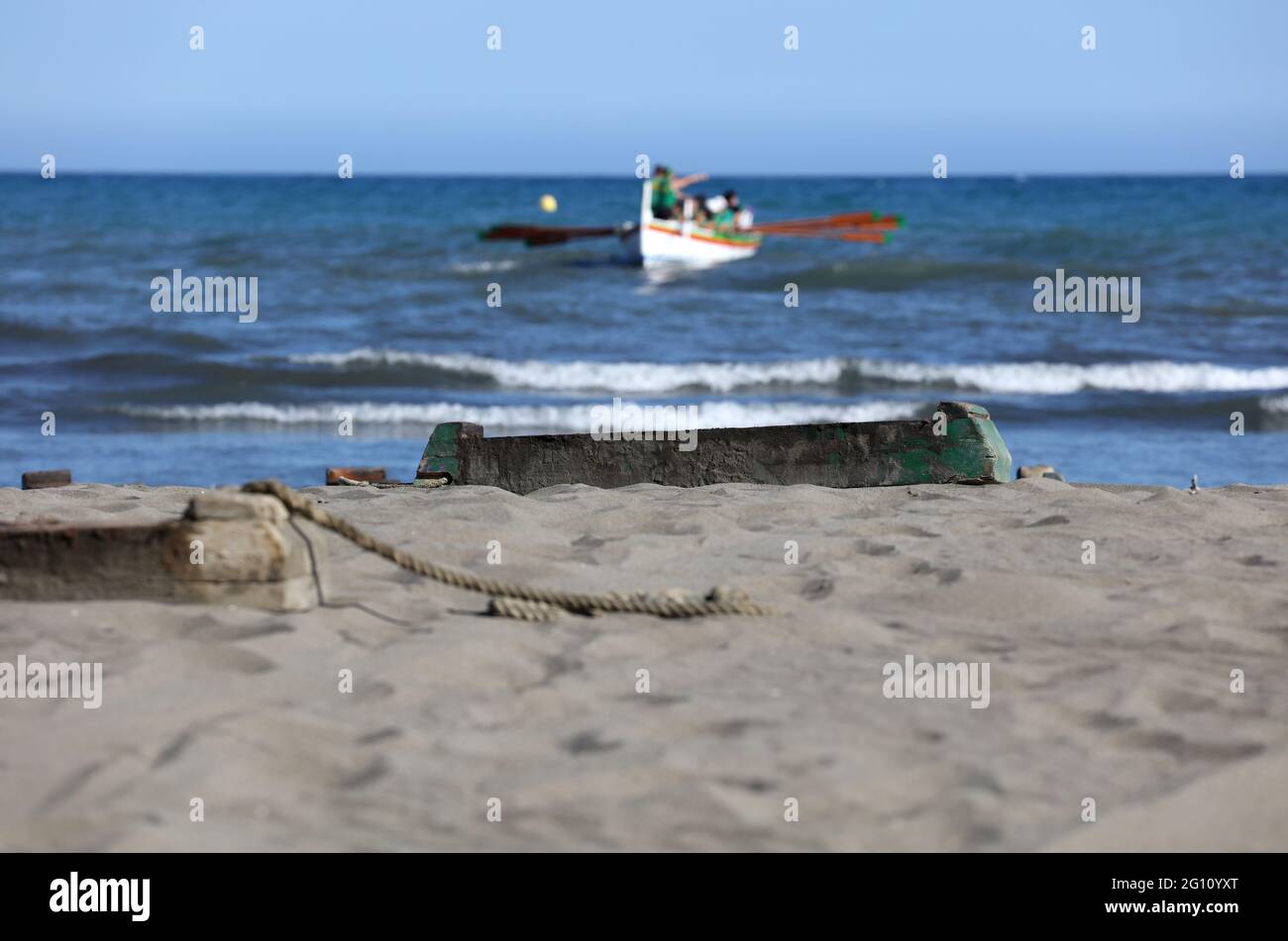 dormeur en bois sur la plage de sable avec bateau à ramer en arrière-plan,  avec ciel bleu Photo Stock - Alamy