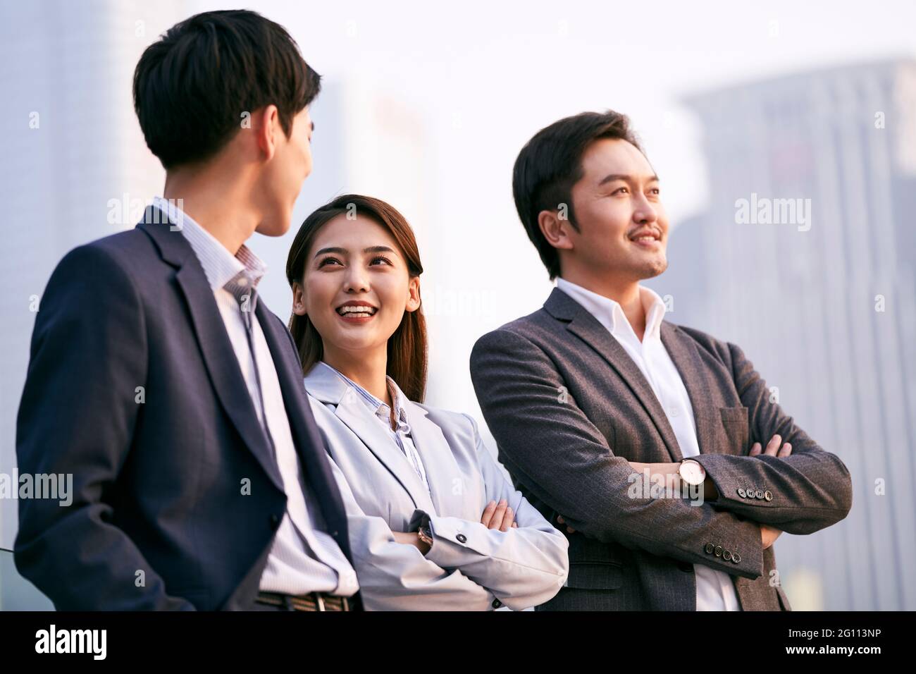 une équipe de trois hommes d'affaires asiatiques discutant en extérieur pour discuter d'affaires Banque D'Images