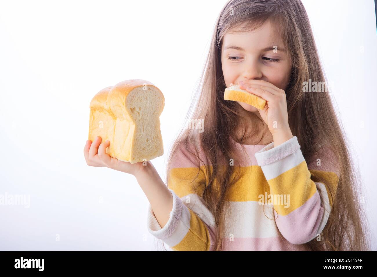 Une petite fille tient une tranche de pain sain fait maison Banque D'Images