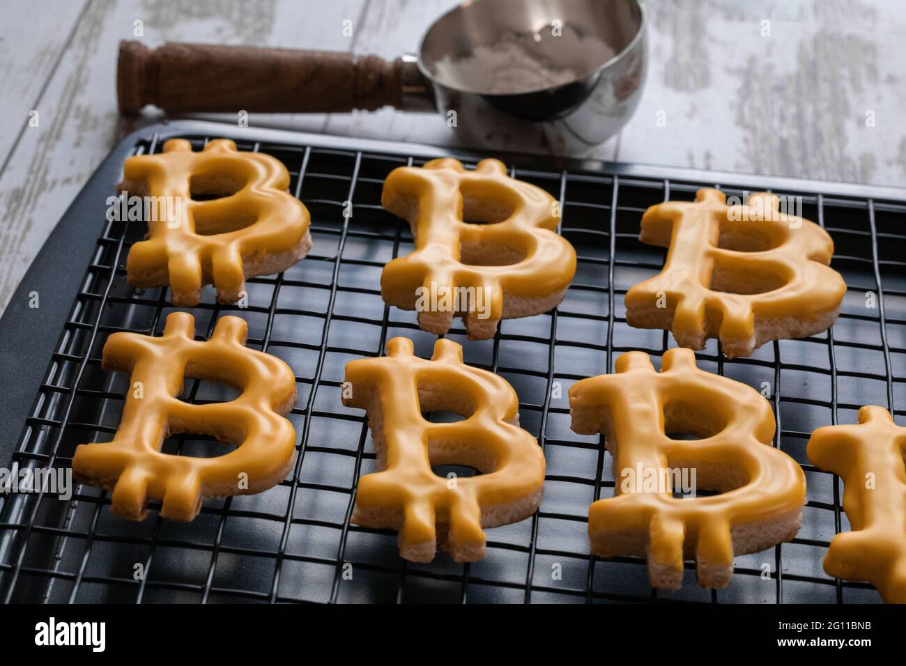 Biscuit en forme de crypto-monnaie B avec glaçage orange sur une plaque de  séchage à la lumière naturelle Photo Stock - Alamy