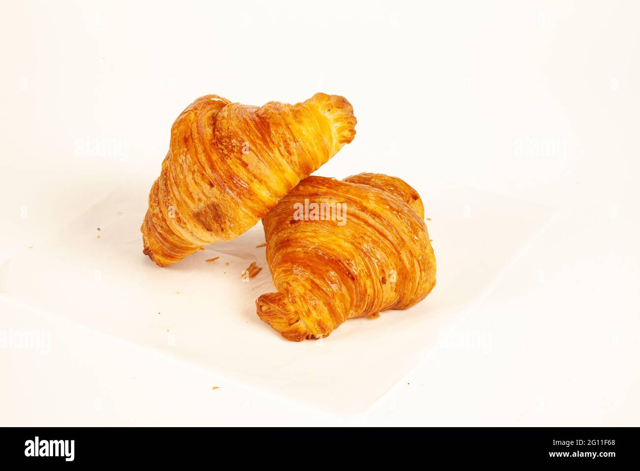 Brioche simple au beurre croustillant croissant et doré de couleur isolée sur fond blanc Banque D'Images