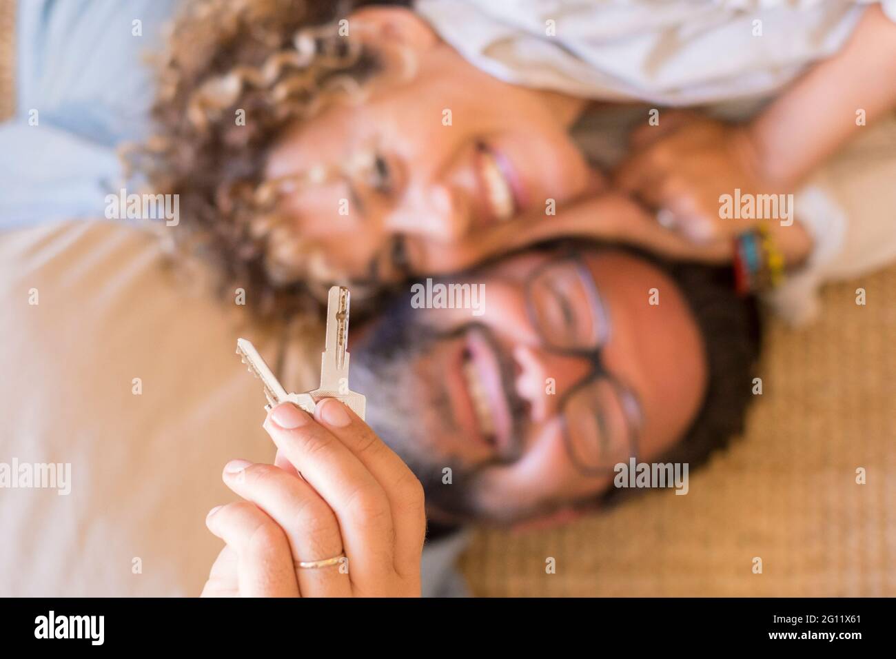 Un jeune couple heureux montre de nouvelles clés de maison excitées à se déplacer ensemble, souriant amoureux mari adulte et femme surjoyed les acheteurs de la première fois relocaliser les locations Banque D'Images