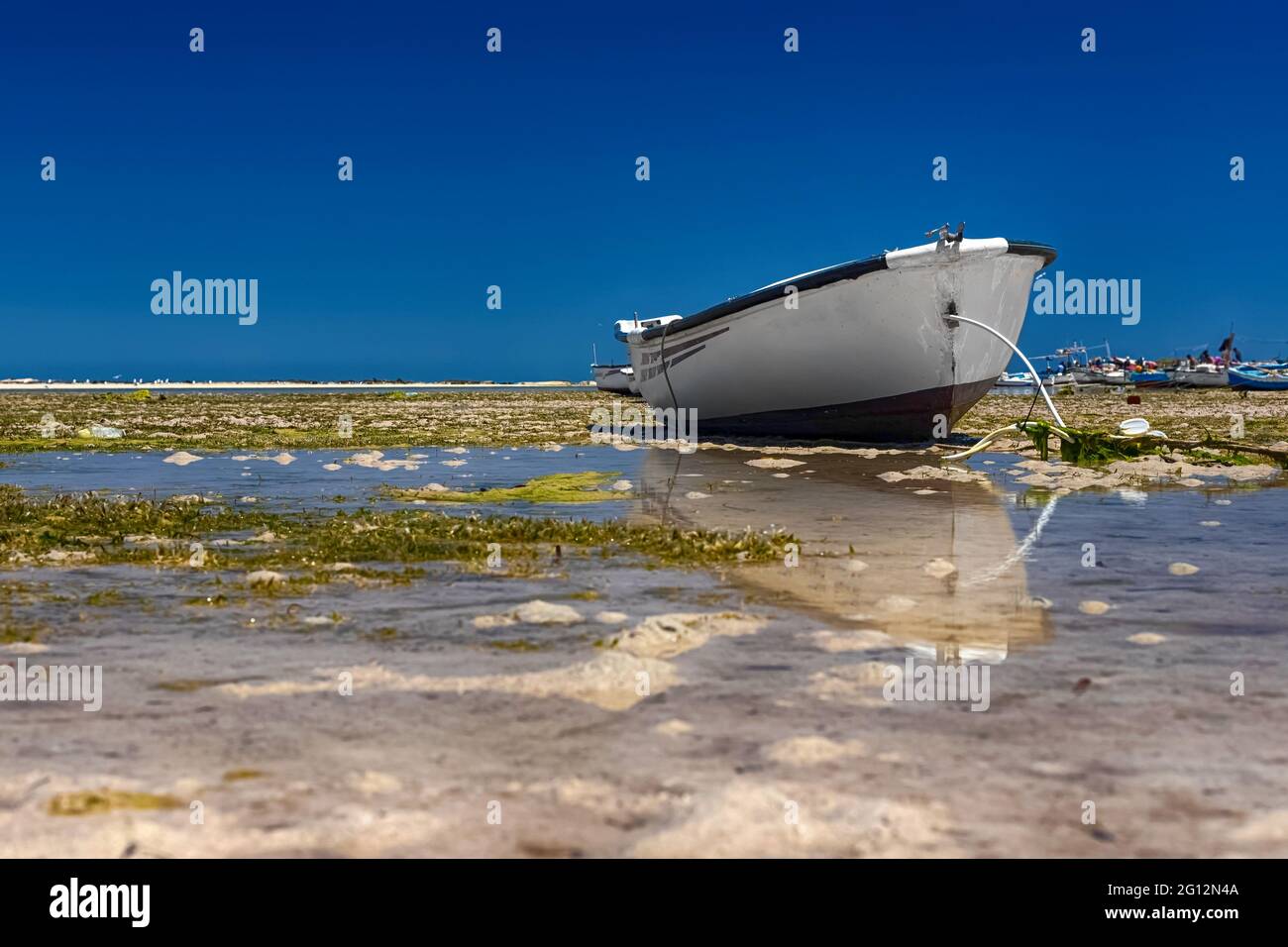 Paysage marin. Belle vue sur le bateau dans la baie de la mer Méditerranée à marée basse sur l'île de Djerba, Tunisie Banque D'Images