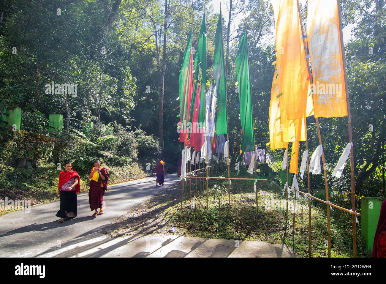 SAMDRUPTSE, SIKKIM, INDE - OCTOBRE 20th 2016 : Monks marchant sur la route de la statue de Samdruptse, drapeaux de prière agitant sur le côté de la route . Samdruptse. Banque D'Images