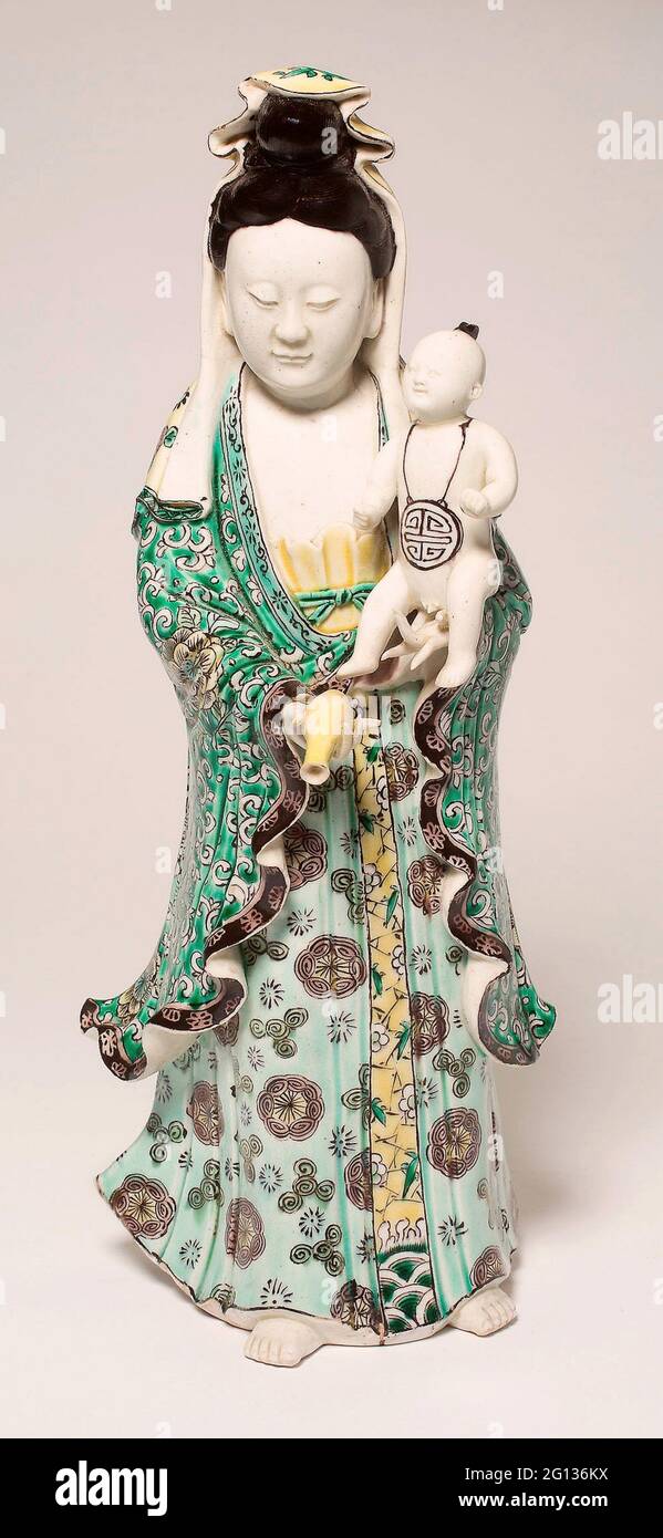 Guanyin tenant un bébé - dynastie Qing (1644 - 1911) - Chine. Porcelaine avec émail de la famille verte sur le biscuit. Banque D'Images
