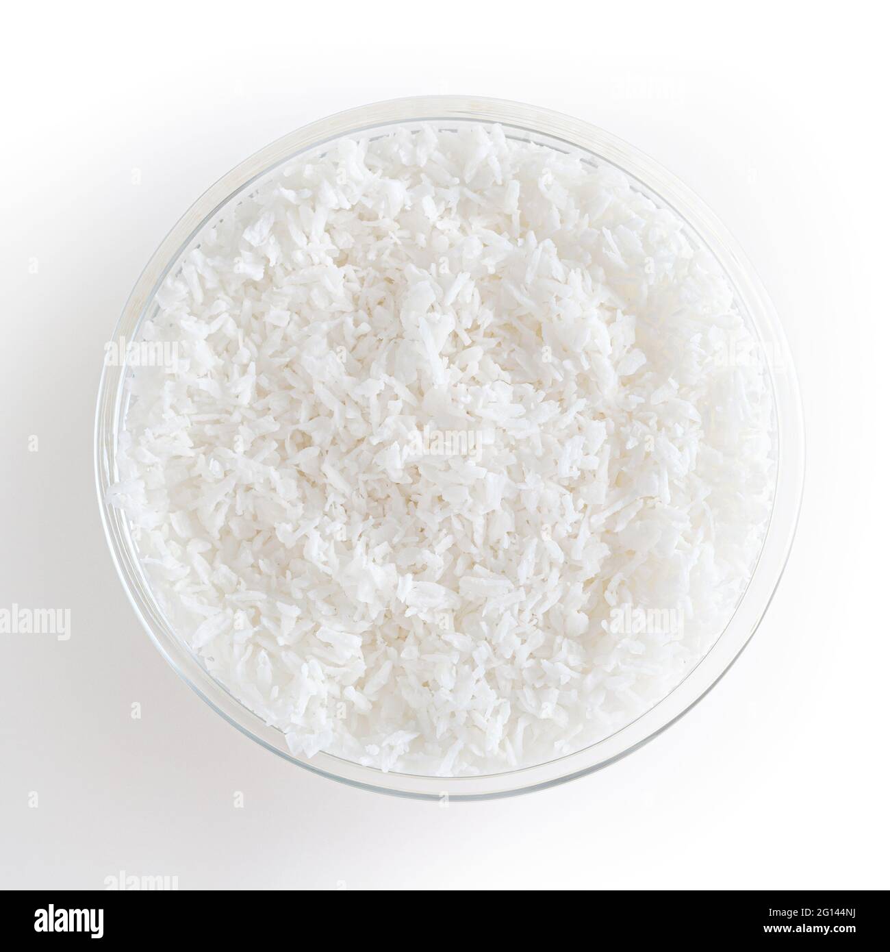 Flocons de noix de coco dans un bol en verre isolé sur fond blanc avec passe-cheveux Banque D'Images