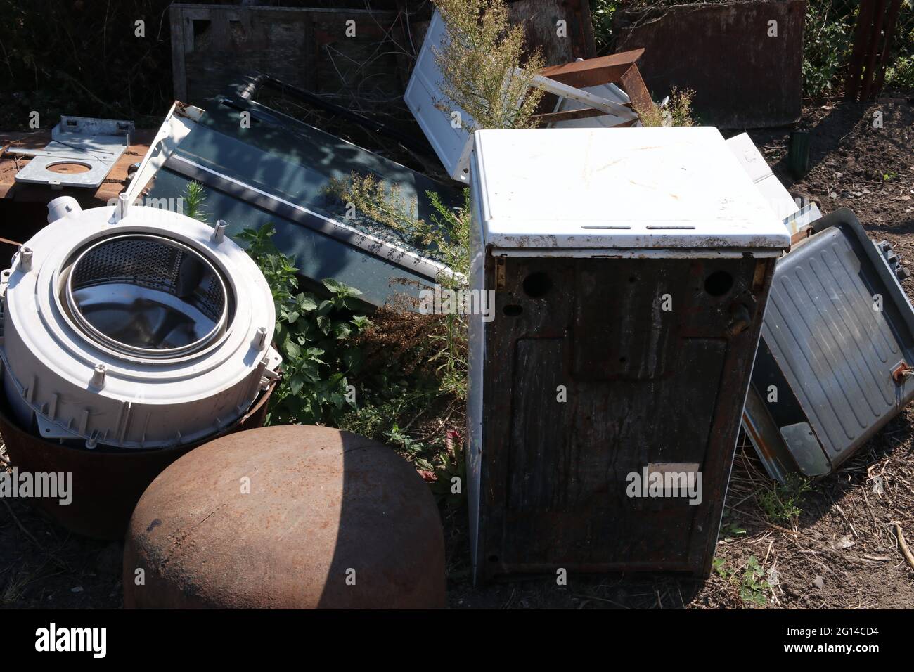 Anciens appareils électroménagers cassés dans une décharge sanitaire. Lave-linge, cuisinière à gaz, etc Banque D'Images