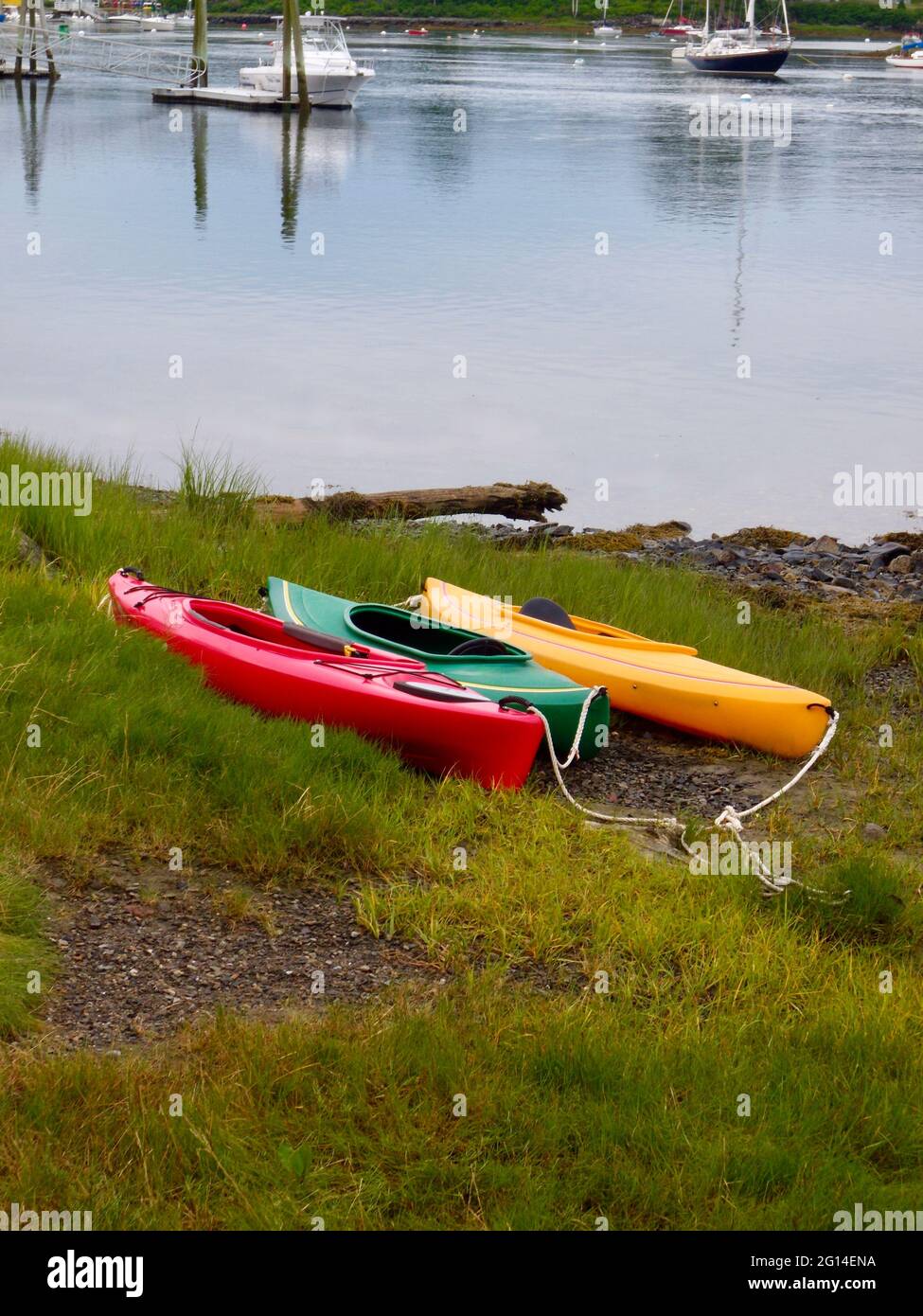 trio de kayaks colorés reposant sur les berges herbeuses Banque D'Images