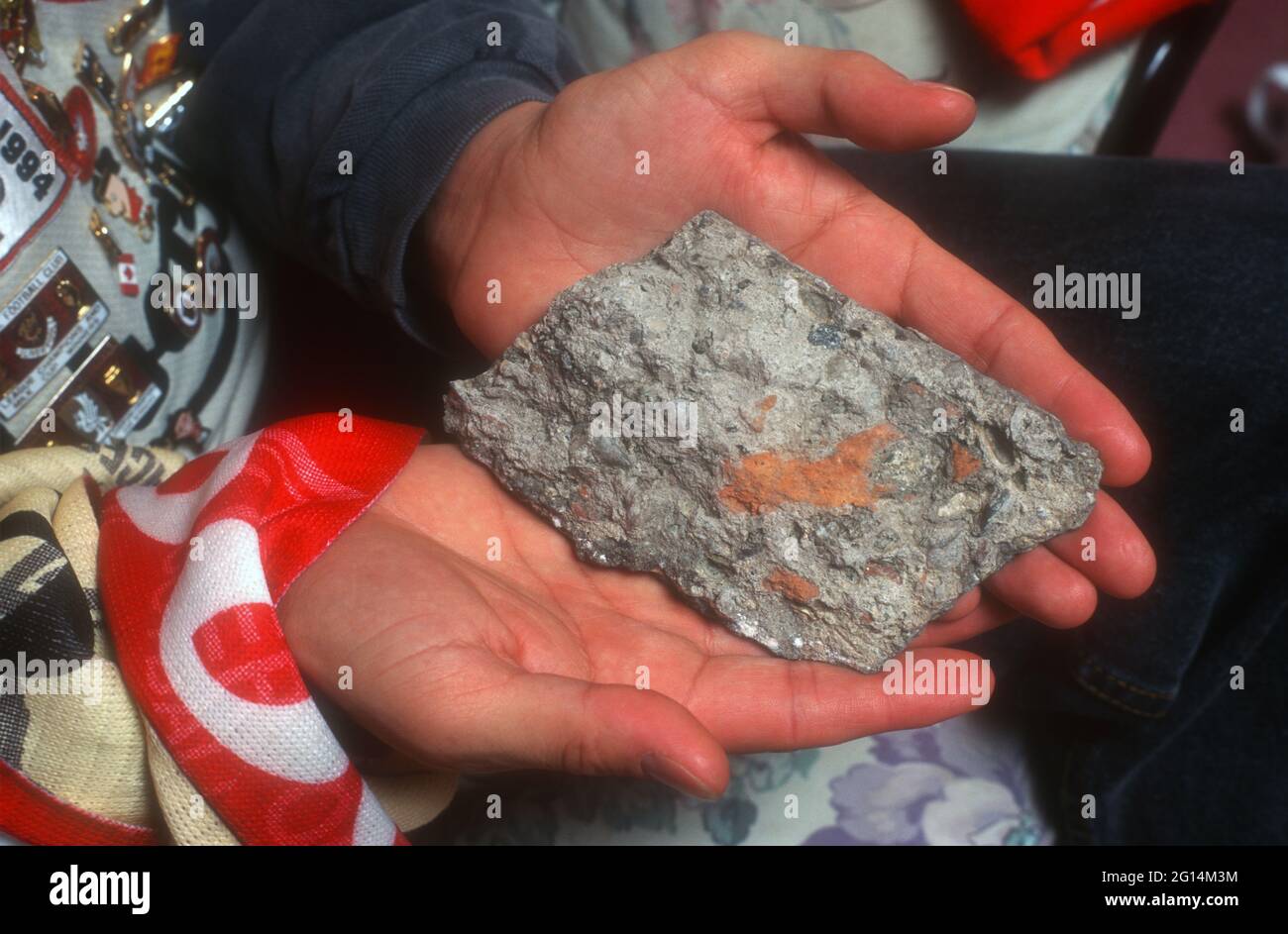 Un supporter de Liverpool tenant un morceau de roche de la base originale d'Anfield Kop Banque D'Images
