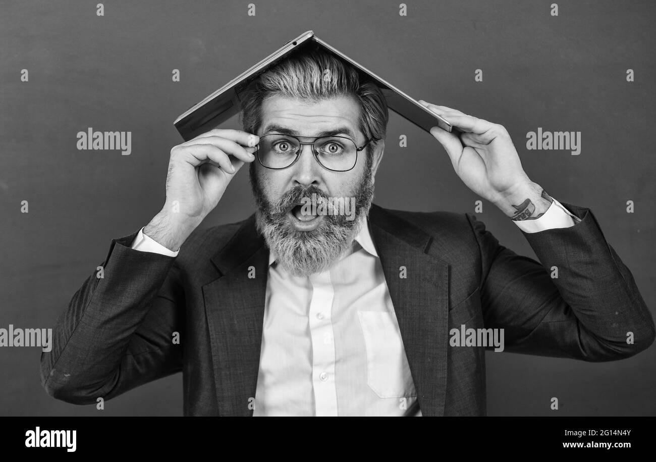 Beaucoup d'informations. Homeschooling. Folie en ligne. Fournir des informations à jour précises. Un professeur tient un ordinateur portable pour surfer sur Internet. Ordinateur portable homme barbu allumé Banque D'Images