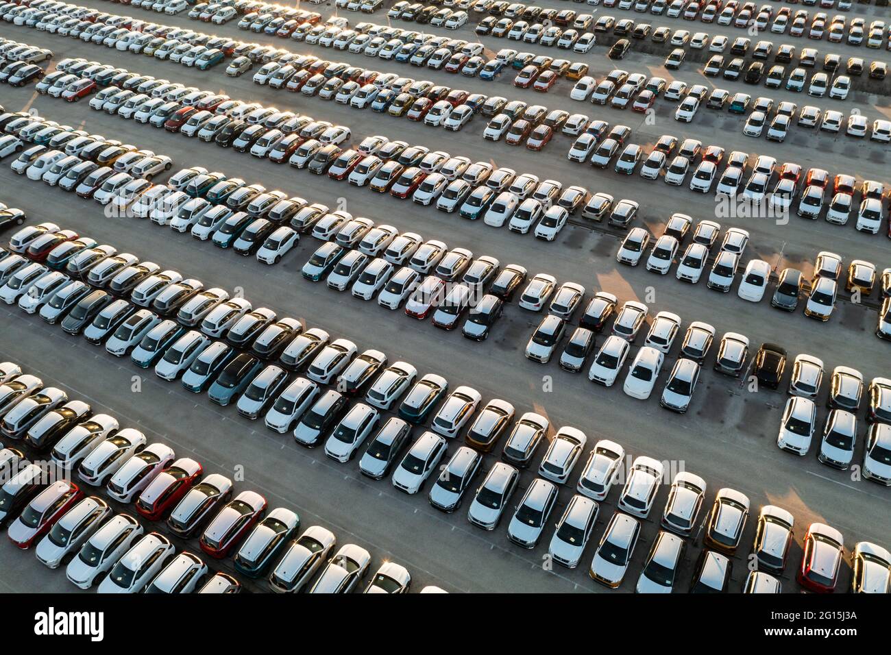 Vue aérienne de nouvelles voitures alignées dans le parking pour l'importation et l'exportation logistique d'affaires à la concession pour la vente, automobile et voiture par Banque D'Images
