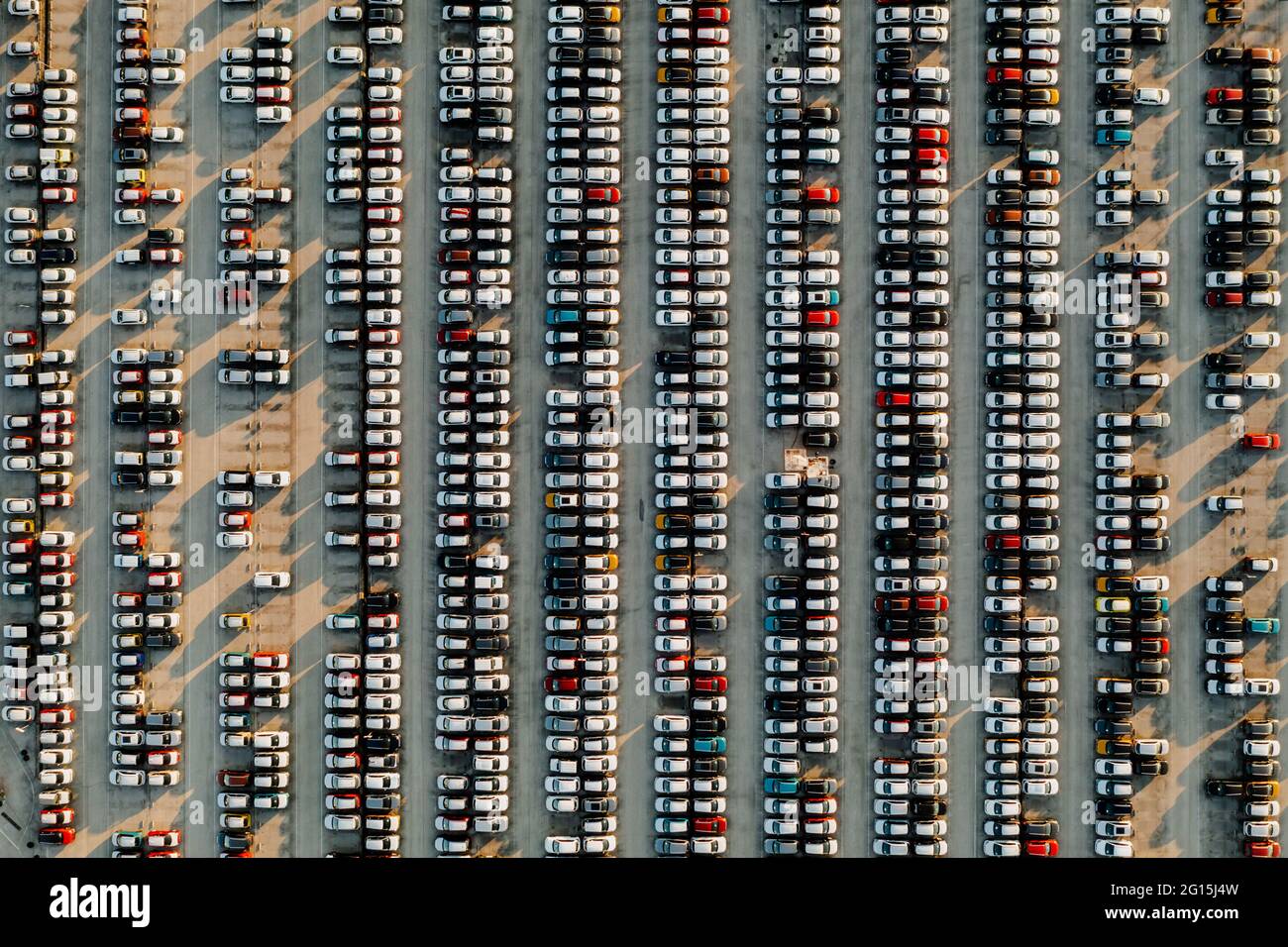 Vue aérienne de nouvelles voitures alignées dans le parking pour l'importation et l'exportation logistique d'affaires à la concession pour la vente, automobile et voiture par Banque D'Images