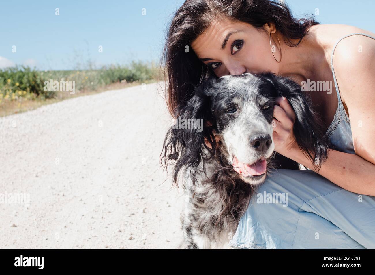 Femme avec un chien, marchant et s'embrassant lors d'une journée d'été avec de l'espace pour le texte Banque D'Images