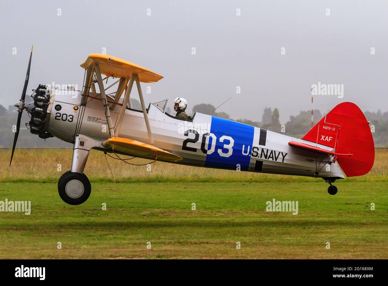 Un avion biplan modèle 75 de Boeing Searman des années 1930 aux couleurs de la marine américaine vient pour un atterrissage Banque D'Images