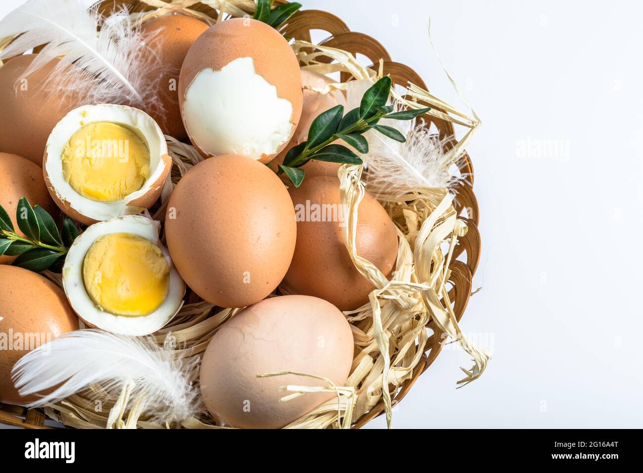 Œufs bio dans le panier et œuf dur avec jaune, concept alimentaire de saison de pâques Banque D'Images
