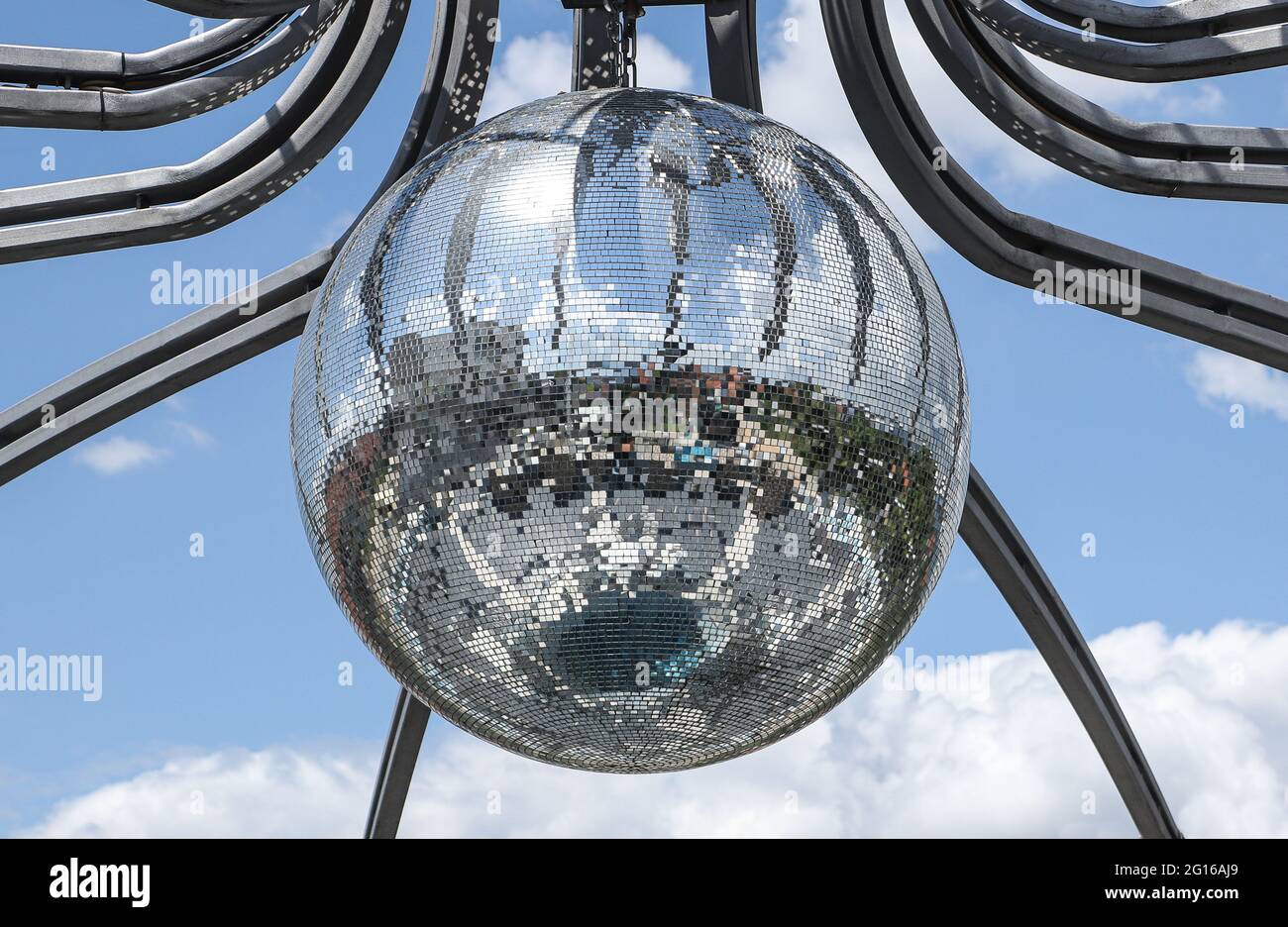 Grande boule de miroir disco suspendue sur la construction métallique  moderne avec ciel nuageux derrière elle Photo Stock - Alamy