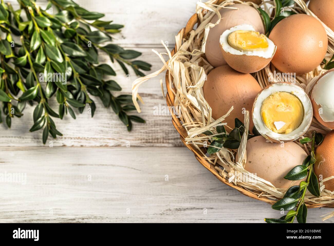 Œufs frais de ferme dans le panier et œuf dur isolé sur fond blanc, concept de pâques Banque D'Images