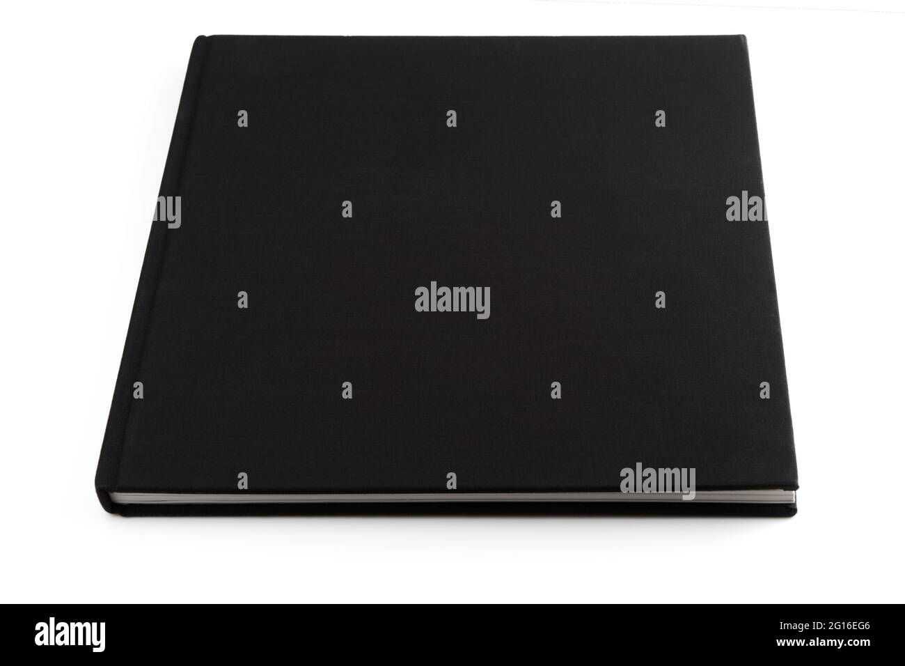 Livre noir couché sur une surface blanche, isolé avec des ombres lisses Banque D'Images