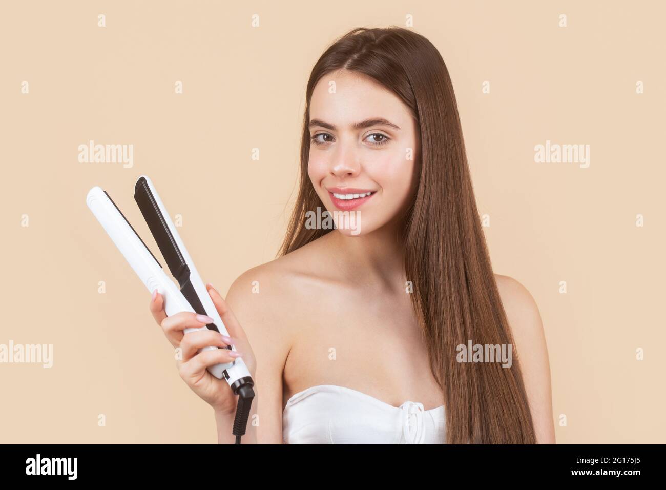 Femme lissant ses cheveux avec un lisseur. Portrait de jeune fille belle en  utilisant le styler sur ses cheveux brillants. Coiffure. Belle femme  souriante Photo Stock - Alamy