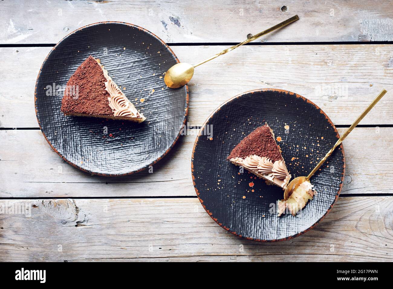 Deux morceaux de gâteau au chocolat sur des assiettes noires, vue du dessus. Banque D'Images