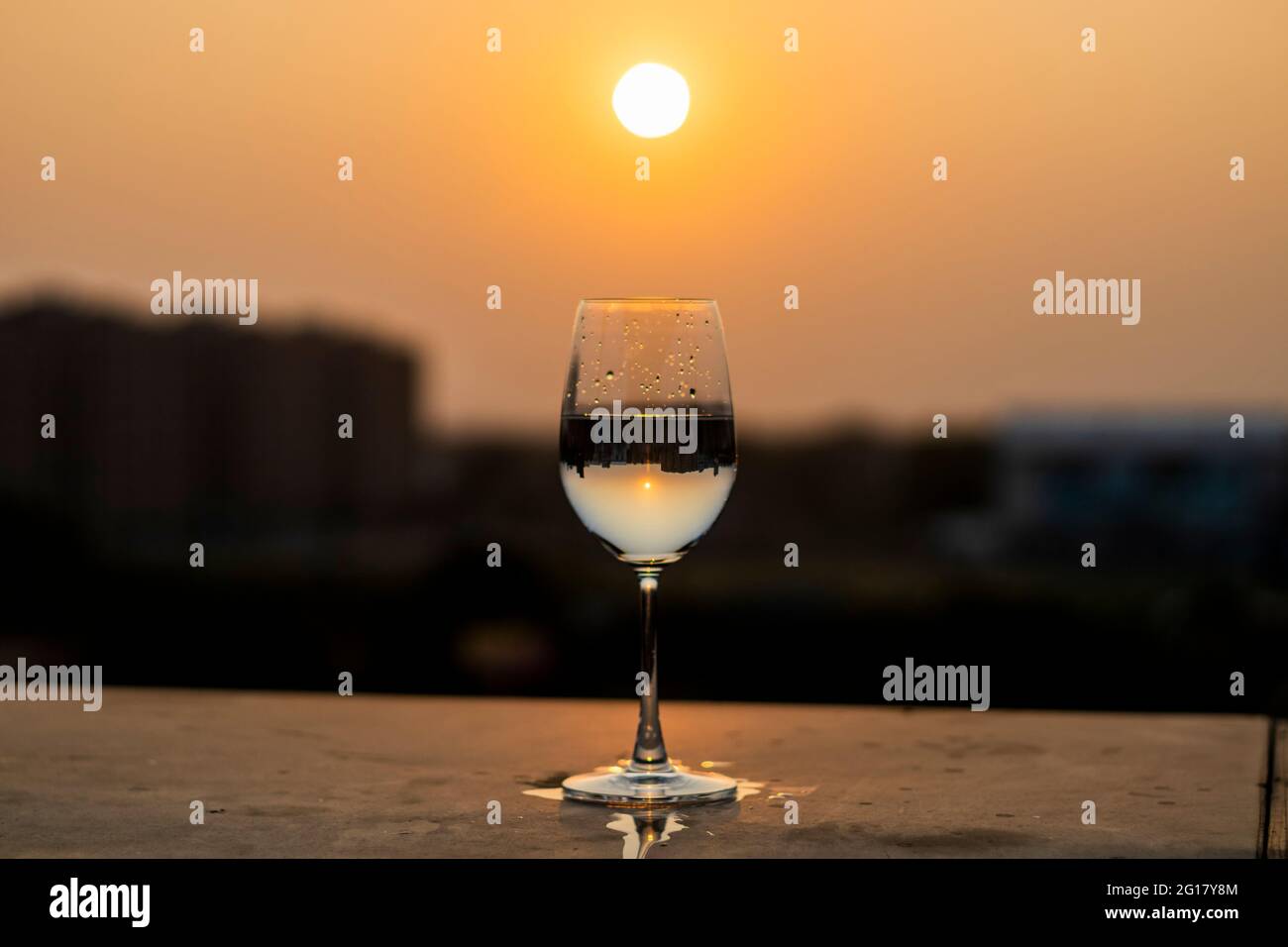 Le liquide est versé dans un verre de vin au coucher du soleil Banque D'Images