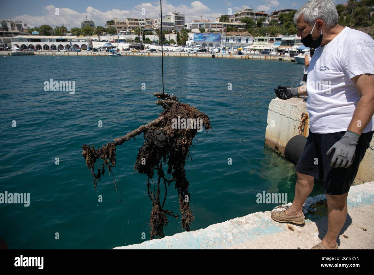 Rafina, Grèce. 5 juin 2021. Un volontaire aide à récupérer une pile de déchets au port de Rafina, à environ 30 km à l'est d'Athènes, Grèce, le 5 juin 2021. La Grèce met en avant la pollution par les plastiques marins, qui marque la Journée mondiale de l'environnement, qui tombe le 5 juin, et la Journée mondiale des océans le 8 juin, avec le lancement par le ministère de la navigation d'un projet de nettoyage de huit ports grecs. Credit: Lefteris Partsalis/Xinhua/Alamy Live News Banque D'Images