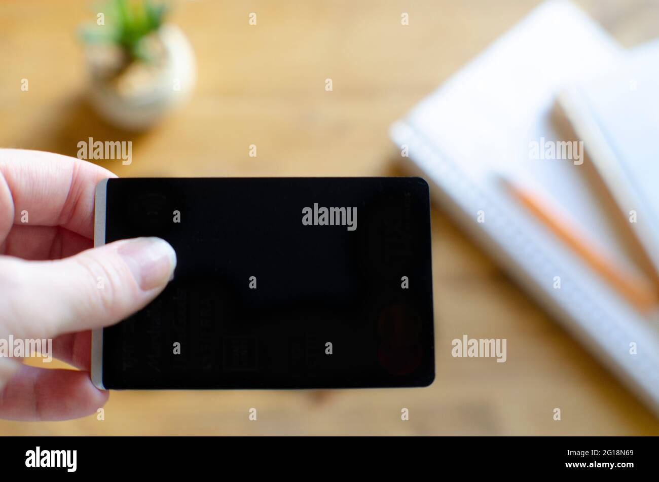 Main avec une carte de crédit vierge noire sur le travail à partir du bureau à la maison Banque D'Images