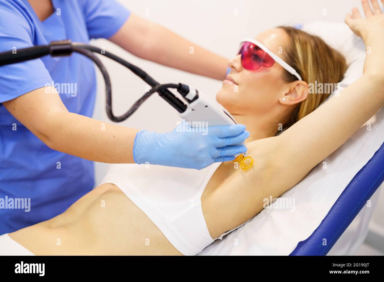 Femme recevant l'épilation laser sous les bras dans un centre de beauté. Banque D'Images