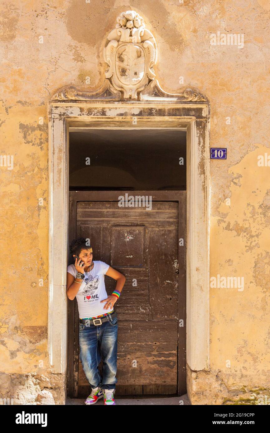 Personne appelant se pencher sur l'embrasure d'une vieille porte. Vieille ville de Bonifacio, Corse, France Banque D'Images