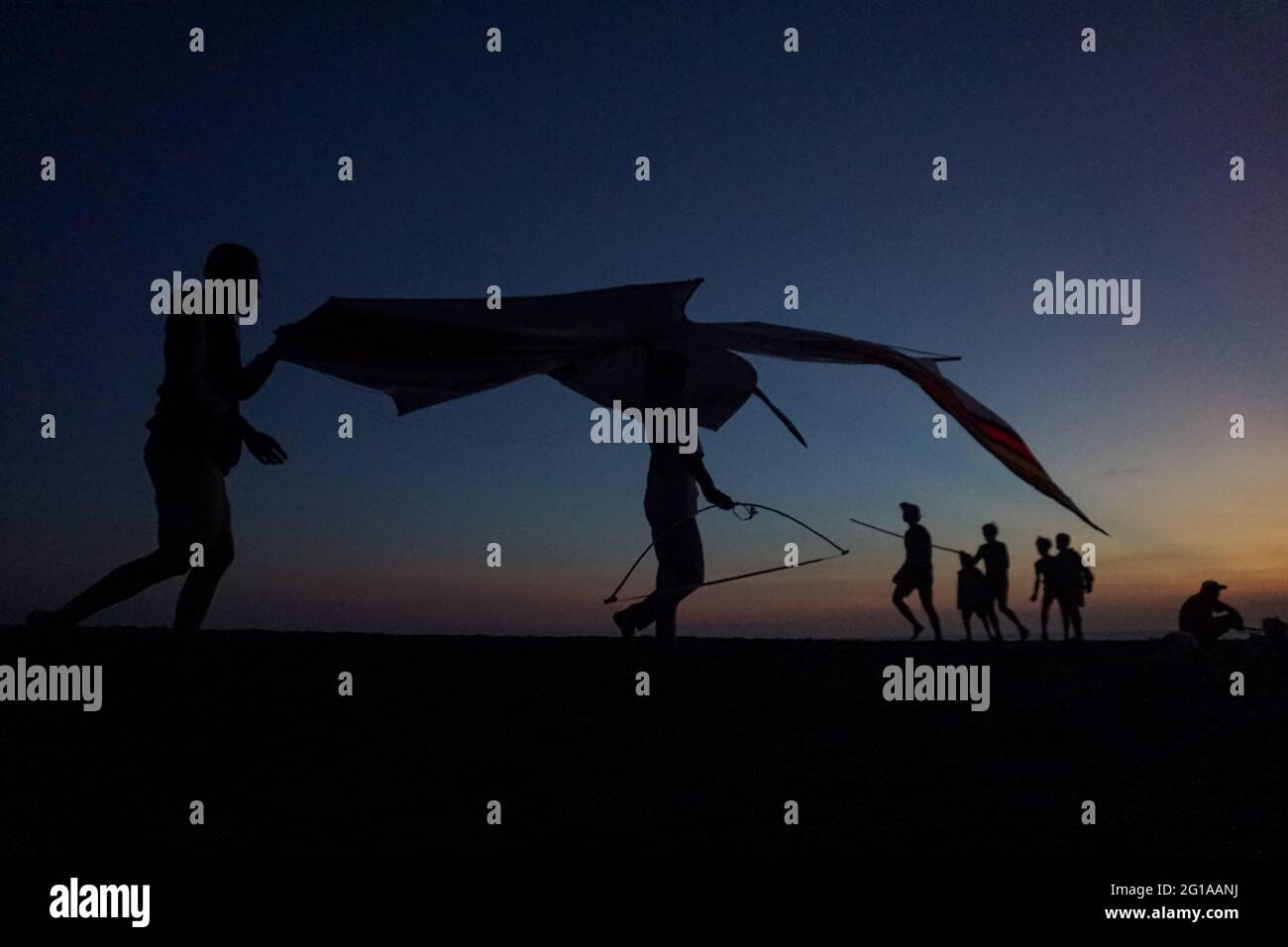 Badung, Bali, Indonésie. 6 juin 2021. La silhouette montre les jeunes balinais voler leur cerf-volant à la plage de Pererenan. La saison des cerfs-volants a lieu de mai à septembre chaque année pendant la saison sèche, et marque le meilleur moment de visite touristique à Bali. Les couleurs du rouge, du blanc, du noir et de l'or jaune représentent l'incarnation des Divinités hindoues balinaises. (Image de crédit : © Dicky BisinglasiZUMA Wire) Banque D'Images