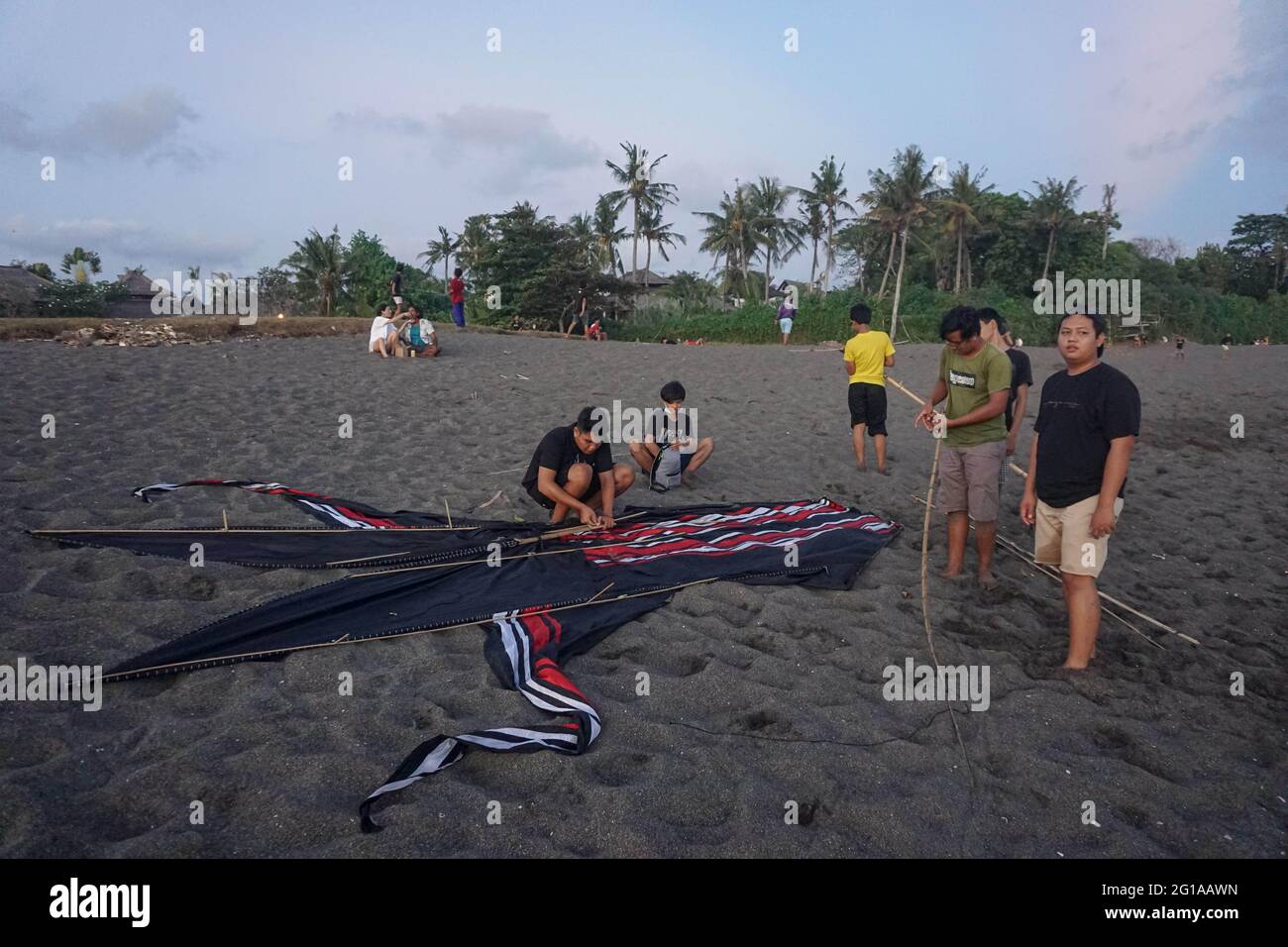 Badung, Bali, Indonésie. 6 juin 2021. Les jeunes balinais préparent leur cerf-volant avant de prendre l'avion sur la plage de Pererenan. La saison des cerfs-volants a lieu de mai à septembre chaque année pendant la saison sèche, et marque le meilleur moment de visite touristique à Bali. Les couleurs du rouge, du blanc, du noir et de l'or jaune représentent l'incarnation des Divinités hindoues balinaises. (Image de crédit : © Dicky BisinglasiZUMA Wire) Banque D'Images