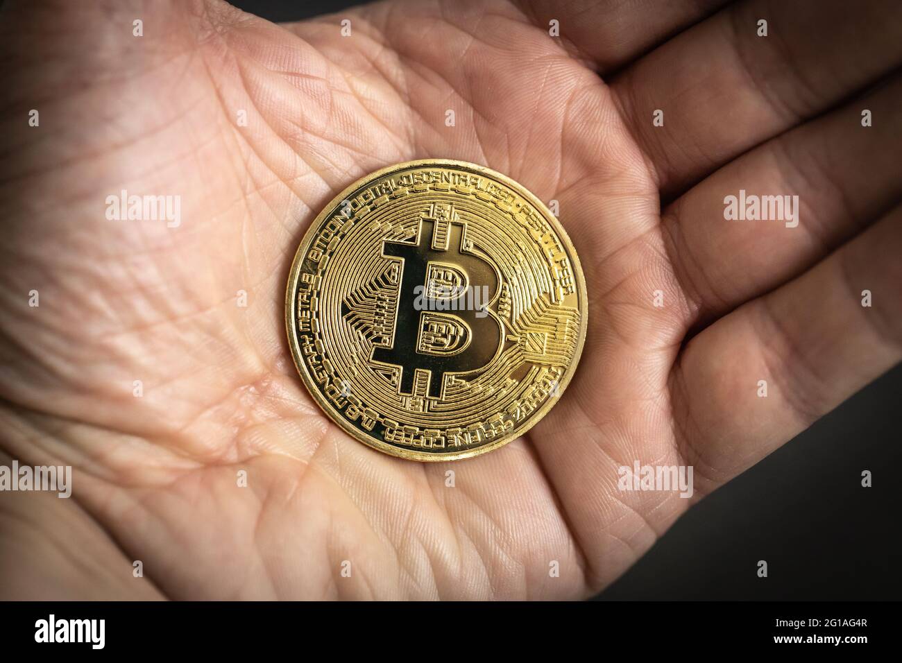 Pièce physique Bitcoin tenue à la main. Banque D'Images