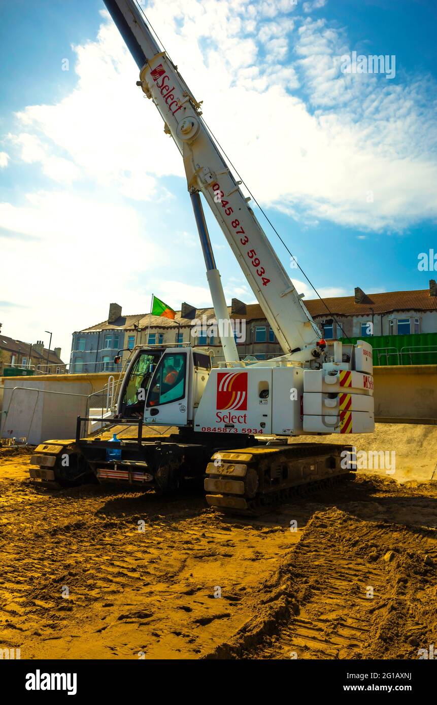 Construction du nouveau Regent Cinema sur le front de mer à Redcar une grande grue télescopique montée sur rail pour le déchargement des camions et l'érection de la structure Banque D'Images