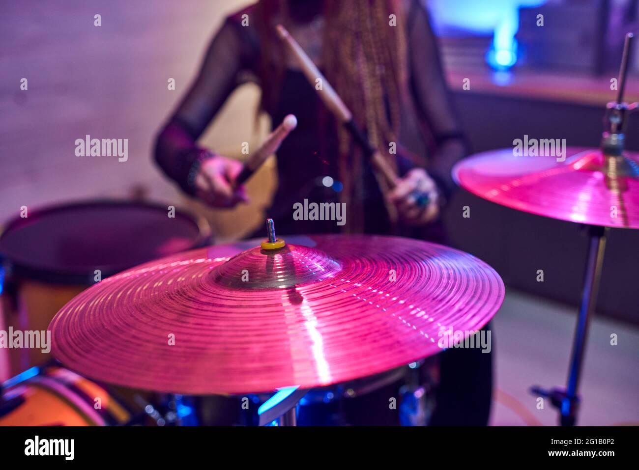 Cymbales de kit de batterie avec une musicienne féminine avec des pilons sur fond Banque D'Images