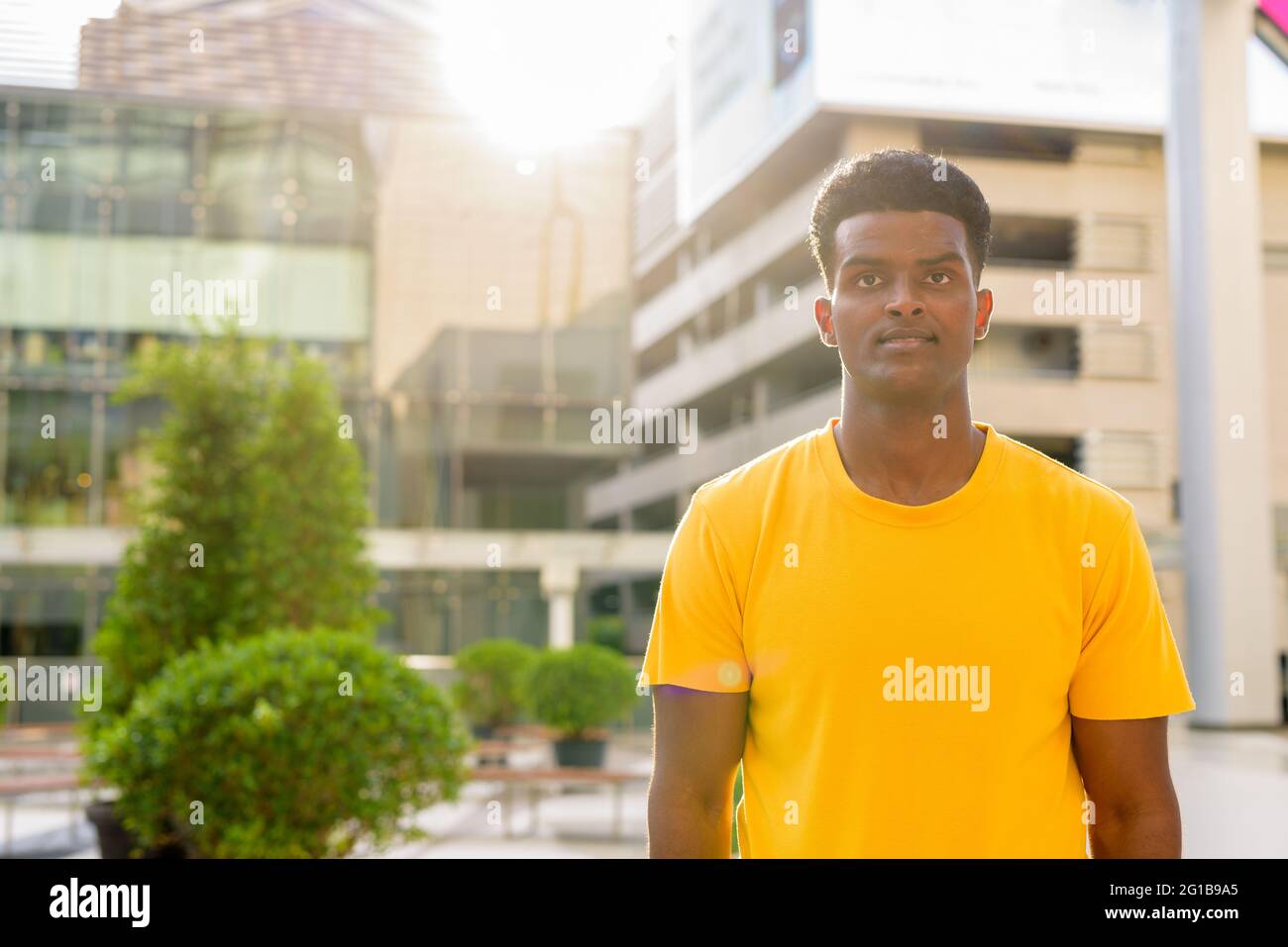 Portrait d'un beau homme africain noir portant un t-shirt jaune à l'extérieur de la ville de Bangkok, Thaïlande Banque D'Images