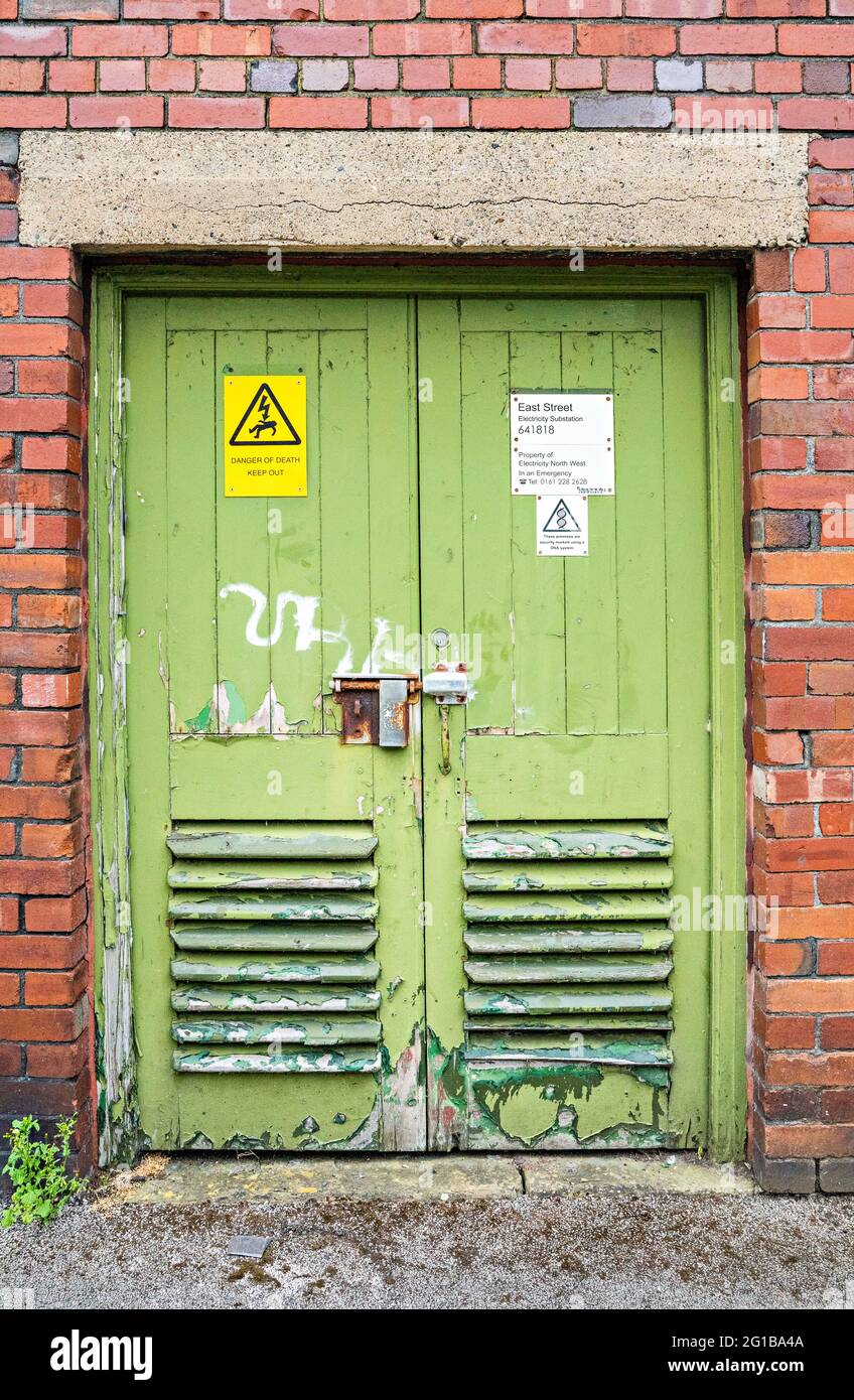 Portes de la sous-station d'électricité avec avis de danger de mort et anciennes serrures Banque D'Images