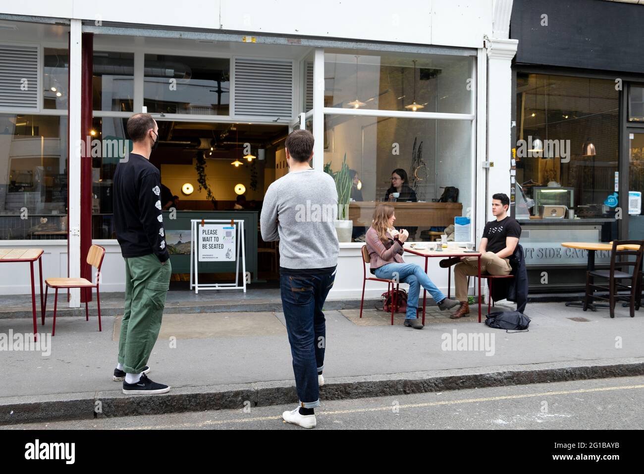 Des hommes qui font la queue dans la file d'attente de la prise de distance sociale à l'extérieur du café Prufrock pendant la pandémie Covid 19 à Exmouth Market Londres Angleterre KATHY DEWITT, Royaume-Uni Banque D'Images
