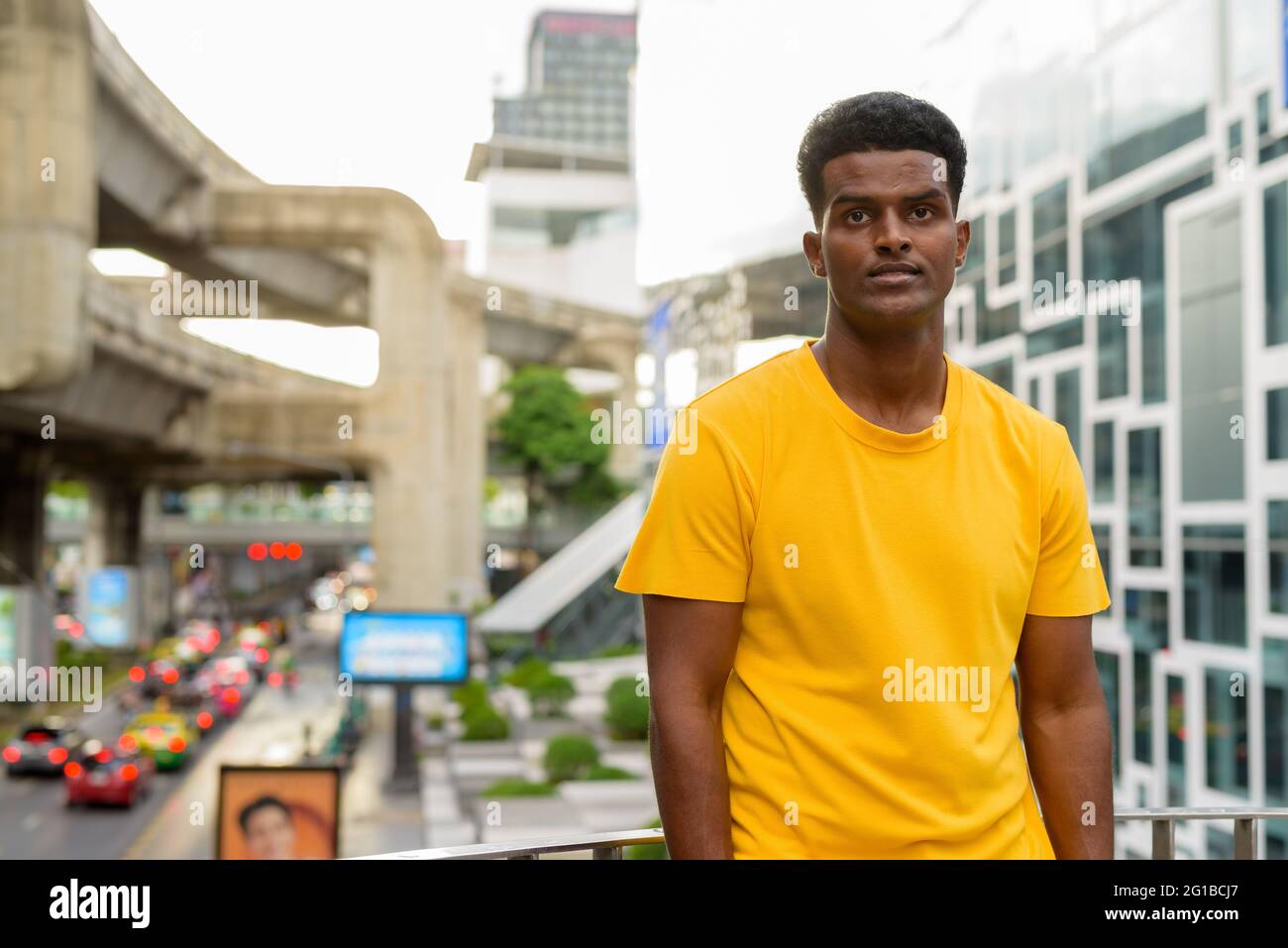Portrait d'un beau homme africain noir portant un t-shirt jaune à l'extérieur de la ville de Bangkok, Thaïlande Banque D'Images