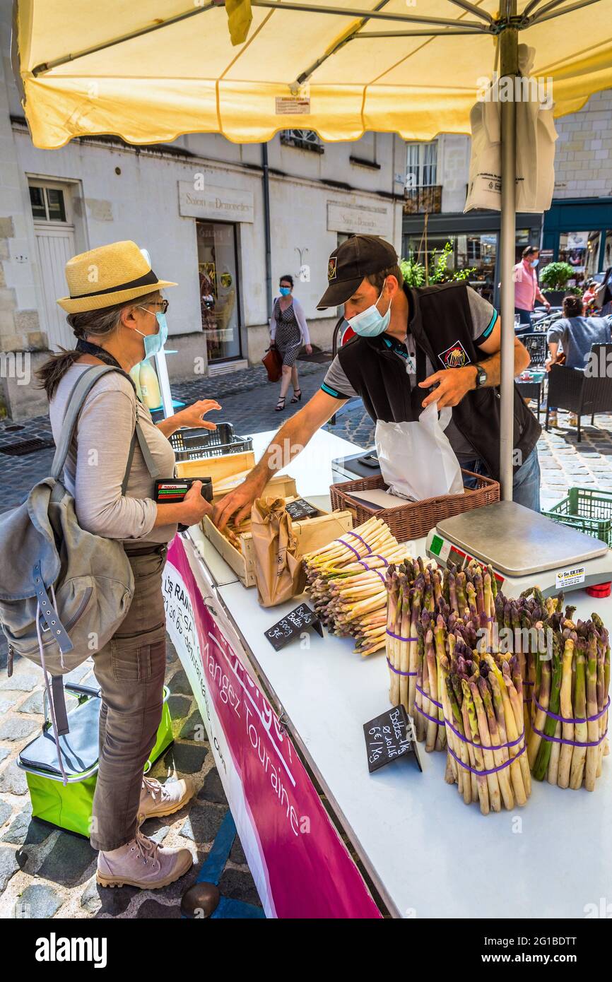 Client en Covid masque visage acheter des asperges fraîches en marché ouvert - Loches, Indre-et-Loire (37), France. Banque D'Images