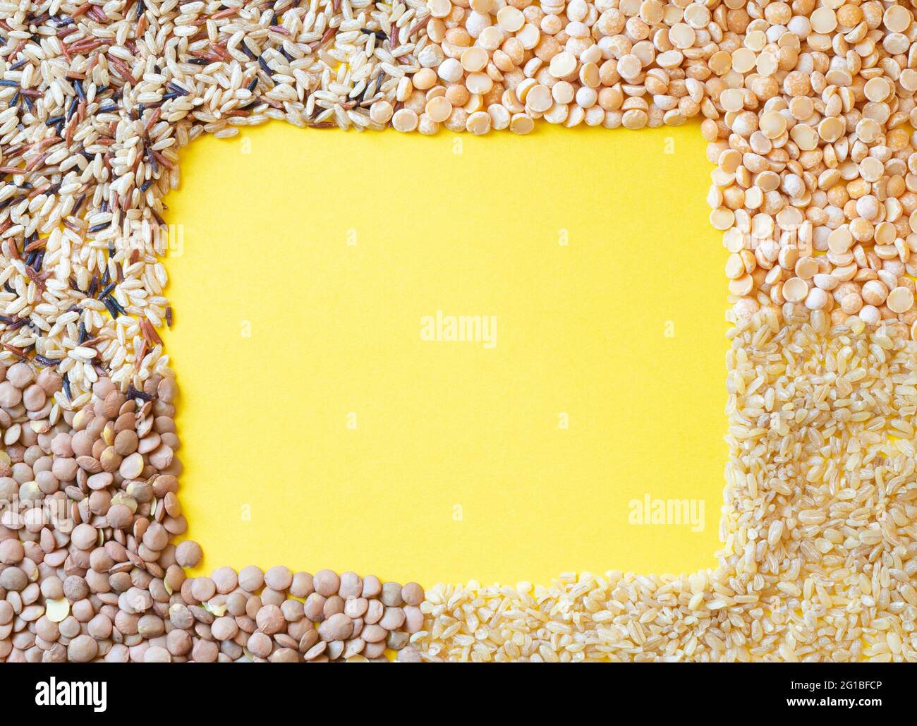 Riz sauvage, lentilles, petits pois et bulgur sur fond jaune.vue du dessus.plat.espace de copie. Banque D'Images